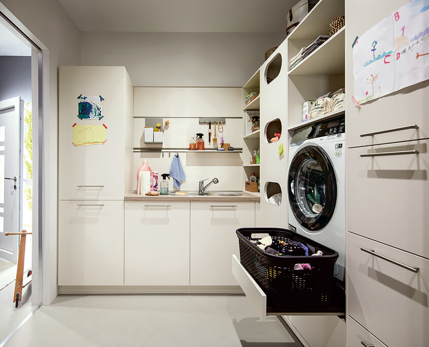 heller Hauswirtschaftsraum mit Waschbecken und Wäschsortierung